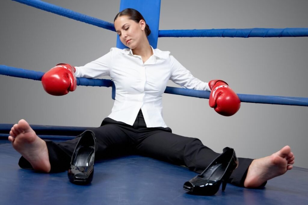 Ritratto di una donna d'affari stanca nei guantoni da boxe che dorme sul ring